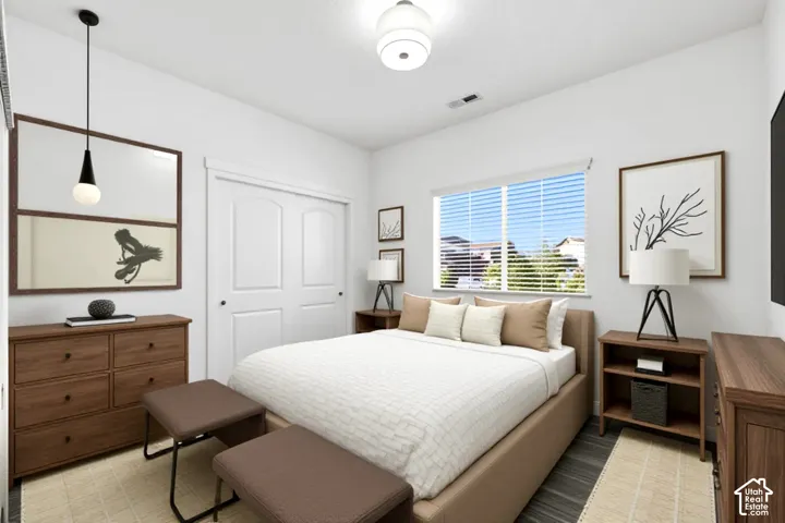 Interior room featuring wood-finish flooring, a contemporary pendant light fixture, a central drum-style ceiling light, and double-door closet cabinetry