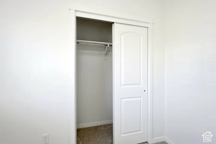 Closet featuring a sliding two-panel door, white interior shelving, and a metal clothing rod