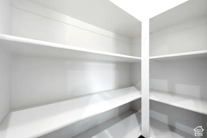 Storage area featuring built-in, multi-level shelving with a crisp white finish