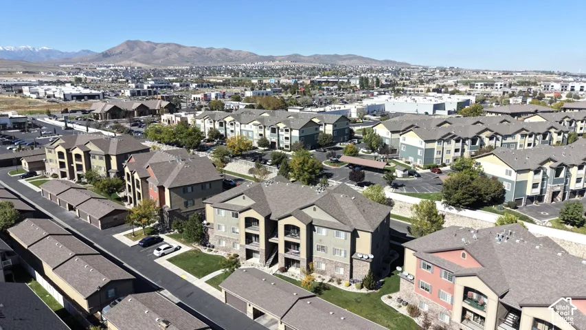 Aerial perspective featuring multi-story residential buildings with shingled rooflines, exterior masonry accents, private balconies, and surrounding mountain range scenery
