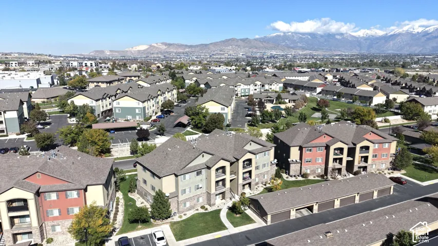 Aerial perspective of multi-family residences featuring stone veneer siding, shingled roofing, private garage structures, and mountain backdrop