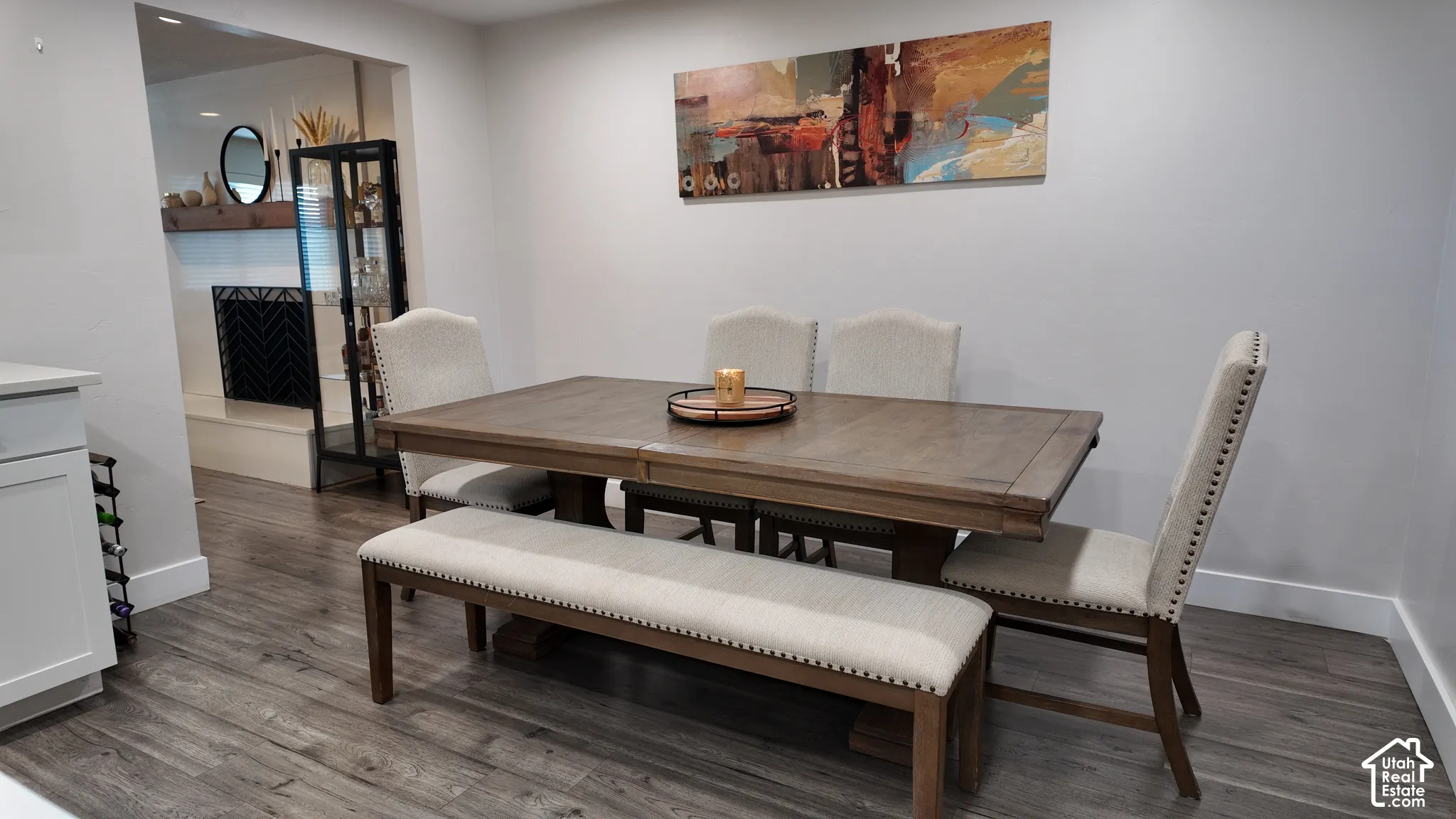 Wood-finish flooring, recessed lighting, and a neutral color palette, featuring a built-in fireplace with a thick natural wood mantel