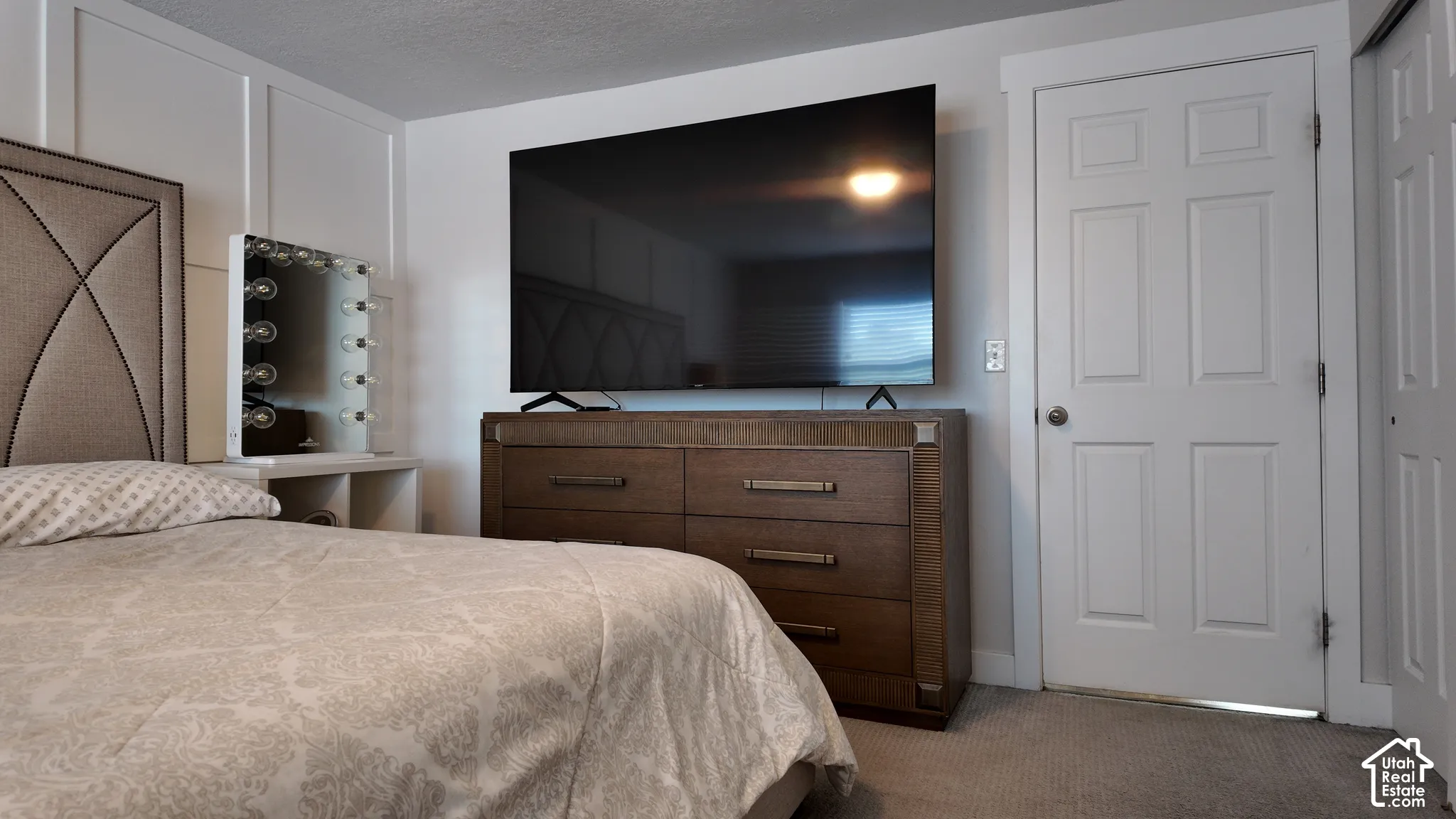 Board-and-batten wall detailing, wall-to-wall carpeting, and a four-panel interior door