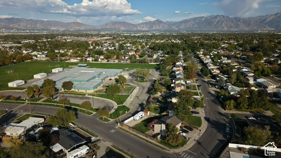 Aerial perspective featuring expansive mountain range backdrop and established residential neighborhood surroundings