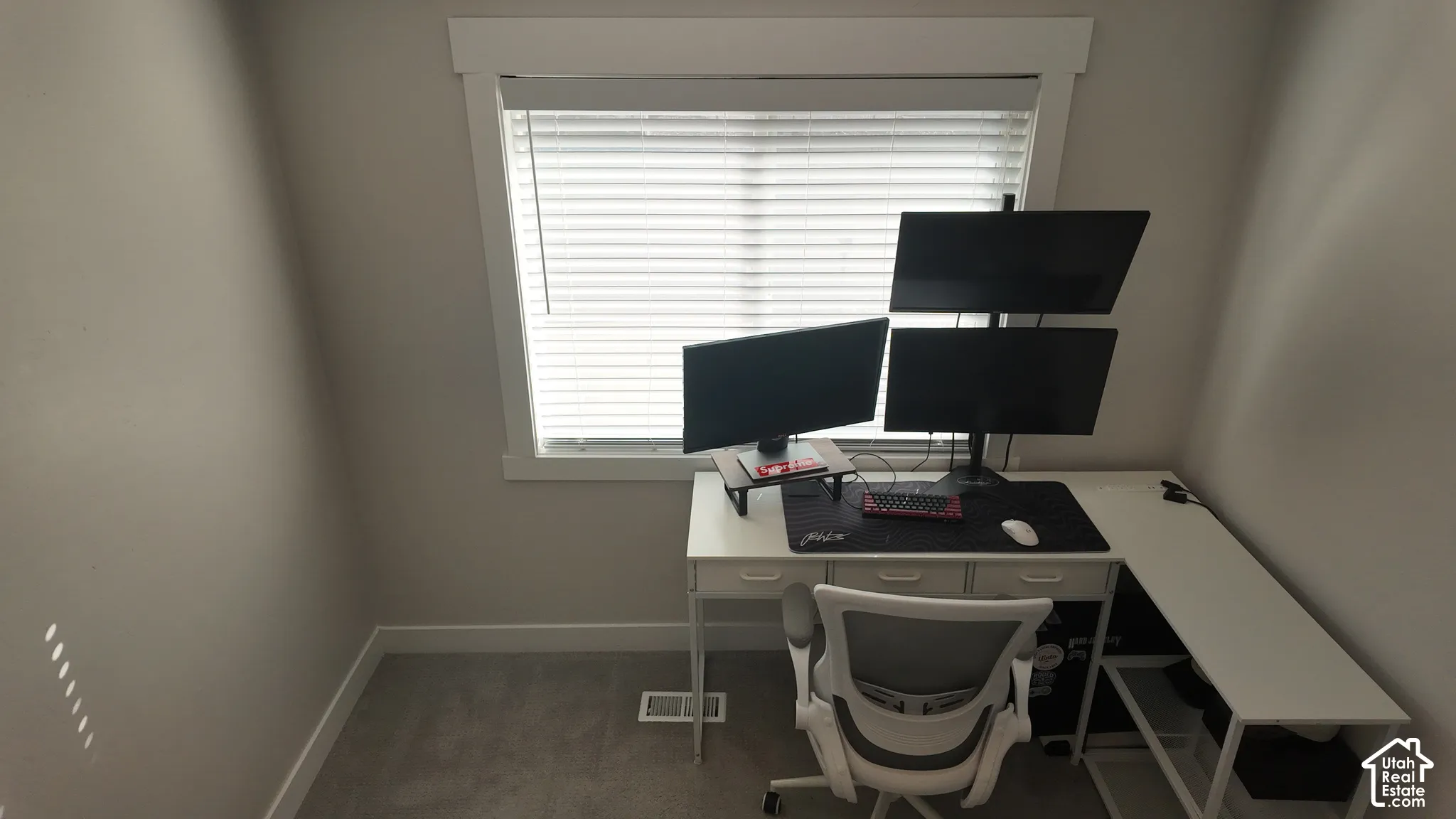 Neutral-toned room featuring a single-pane window with thick white casing and horizontal blinds