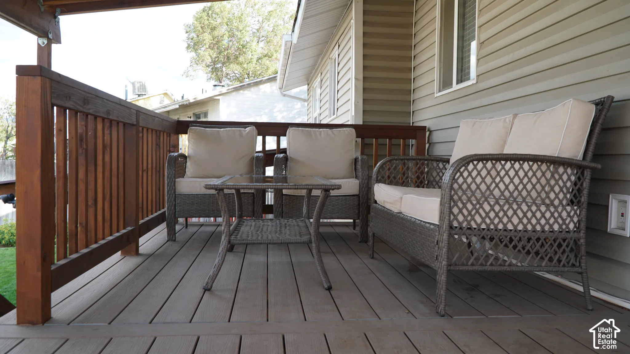 Raised deck featuring wood-finish decking, stained wood railing, and vinyl siding exterior