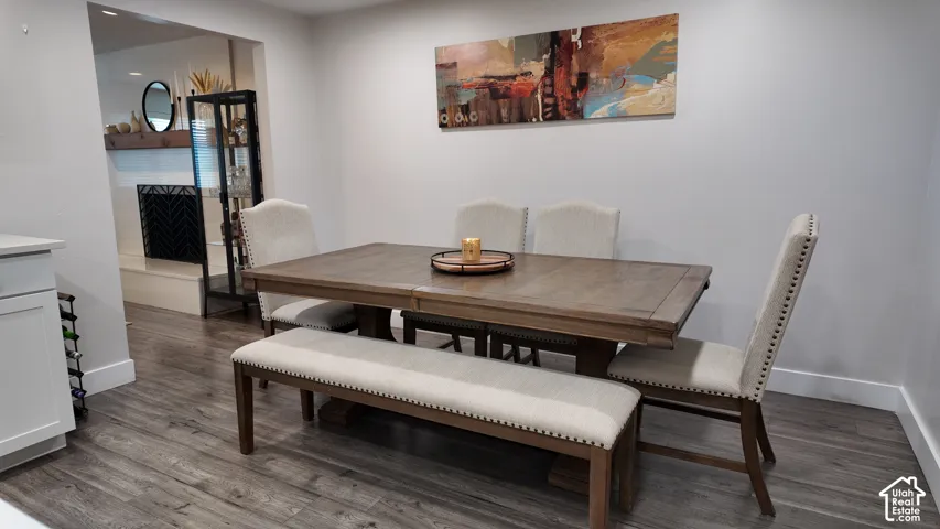 Wood-finish flooring, recessed lighting, and a neutral color palette, featuring a built-in fireplace with a thick natural wood mantel