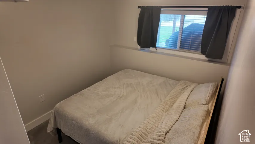 Neutral-toned walls, carpeted flooring, and a sliding window with horizontal blinds