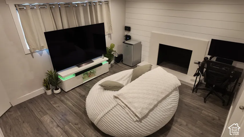 Wood-finish flooring, horizontal shiplap wall detail, and a minimalist fireplace surround