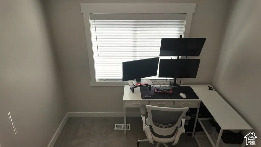Neutral-toned room featuring a single-pane window with thick white casing and horizontal blinds