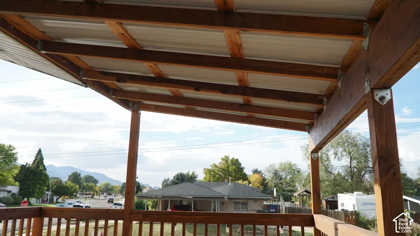 Covered exterior deck featuring natural wood-finish support beams and railings with metal hardware connectors