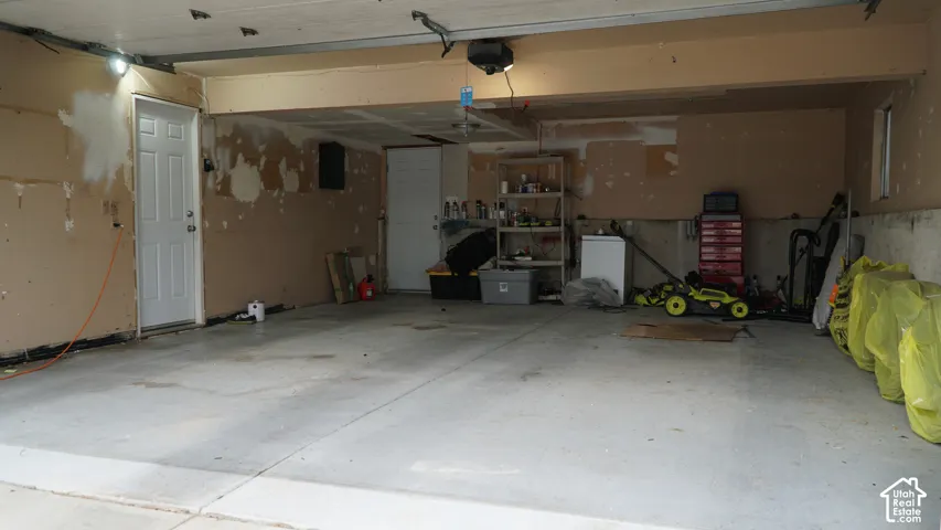 Two-car garage featuring a concrete floor, dual entry doors, and overhead lighting