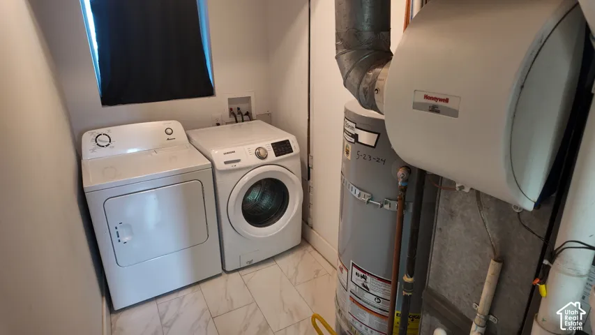 Utility space featuring large-format tile flooring, a dedicated water heater, a furnace unit, and an integrated air filtration system