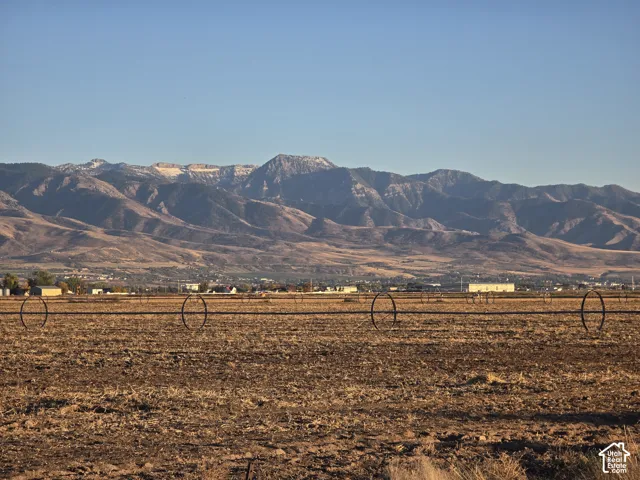 Expansive open acreage featuring metal irrigation wheel lines and prominent mountain range scenery