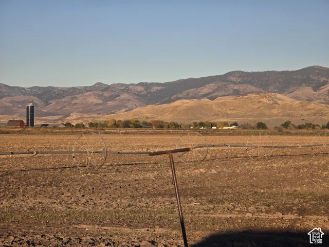Expansive acreage featuring agricultural terrain, permanent irrigation infrastructure, and prominent mountain backdrops