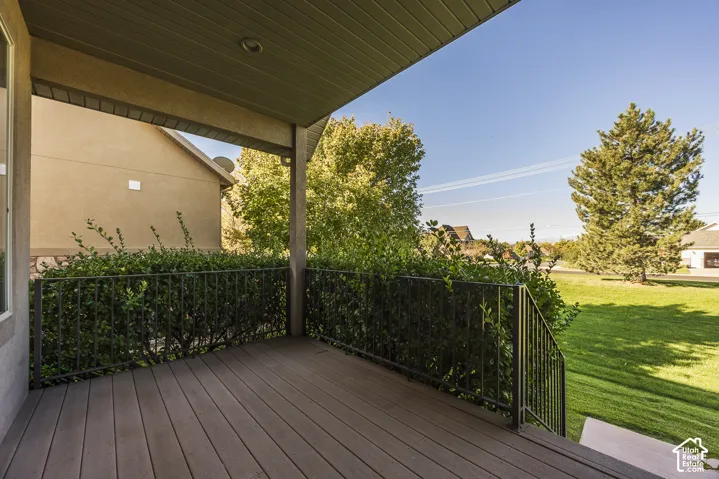 Covered porch featuring wood-finish decking, dark metal railings, and recessed ceiling lighting