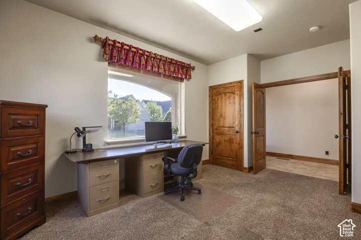 Built-in desk with workspace, wood-finish interior doors, and large picture window