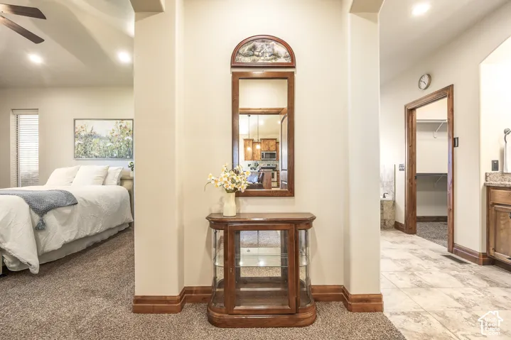 Neutral wall tones featuring recessed ceiling lighting, textured carpet flooring, and natural wood trim accents