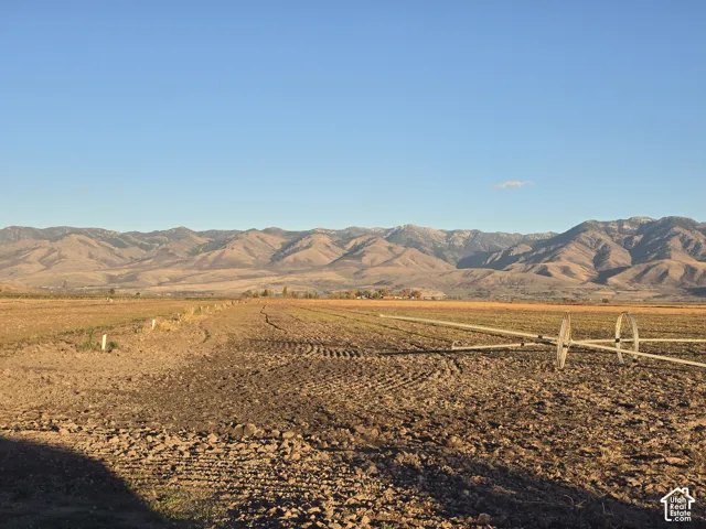 Expansive acreage featuring agricultural land, integrated irrigation equipment, and prominent mountain backdrops