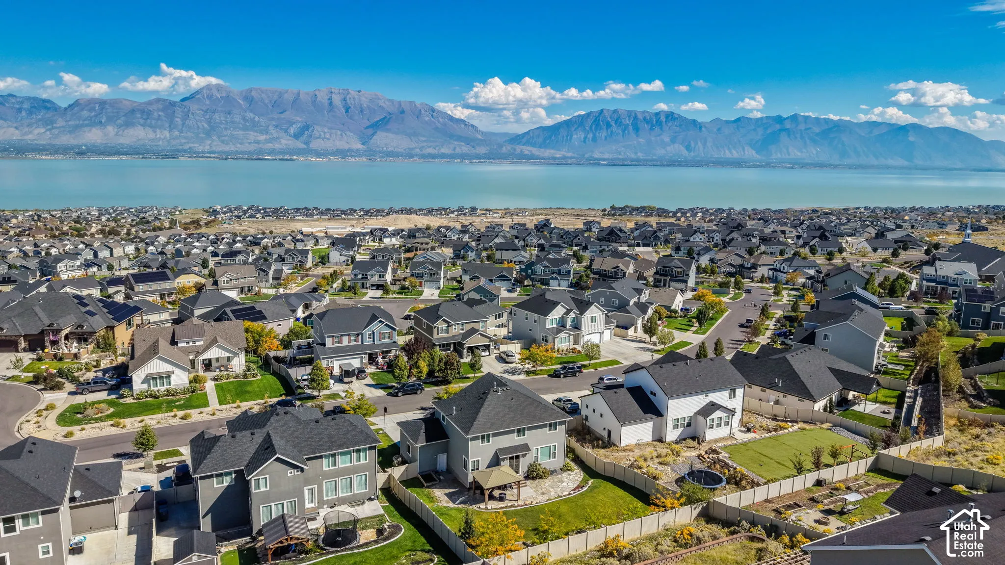 Aerial perspective of the residential area featuring a large lake and mountain backdrop