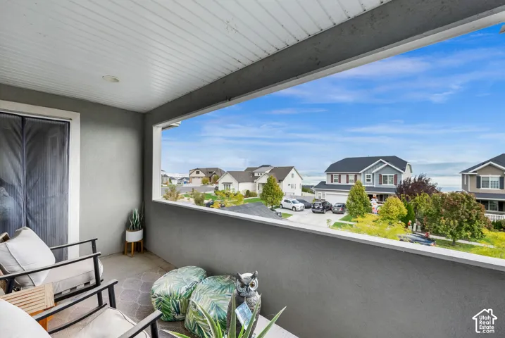 Covered balcony featuring concrete flooring, solid masonry railing, beadboard ceiling, and recessed lighting