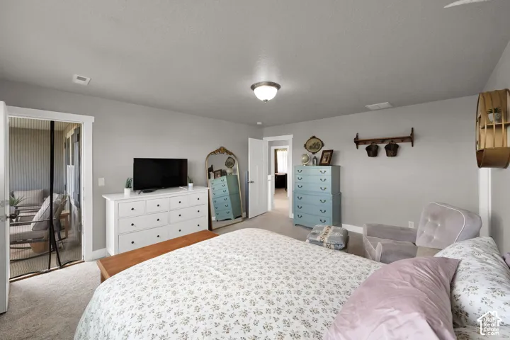 Neutral-toned interior featuring wall-to-wall carpeting, crown molding, a central flush-mount light fixture, and a glass-paneled door opening to a screened-in porch