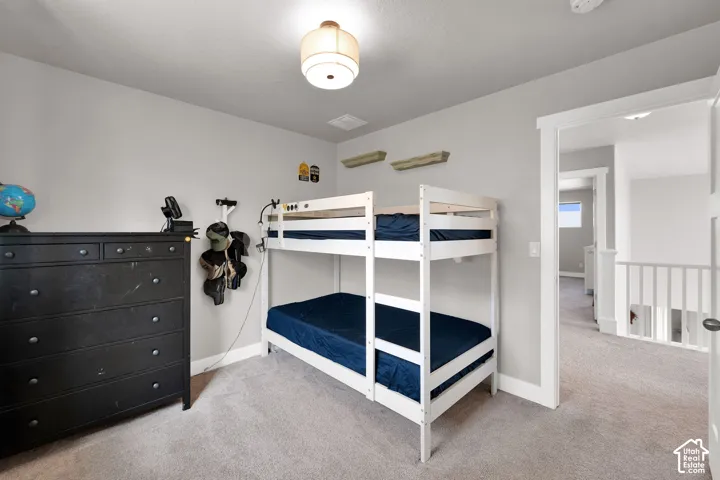 Neutral-toned room featuring wall-to-wall carpeting and a drum-style ceiling light fixture