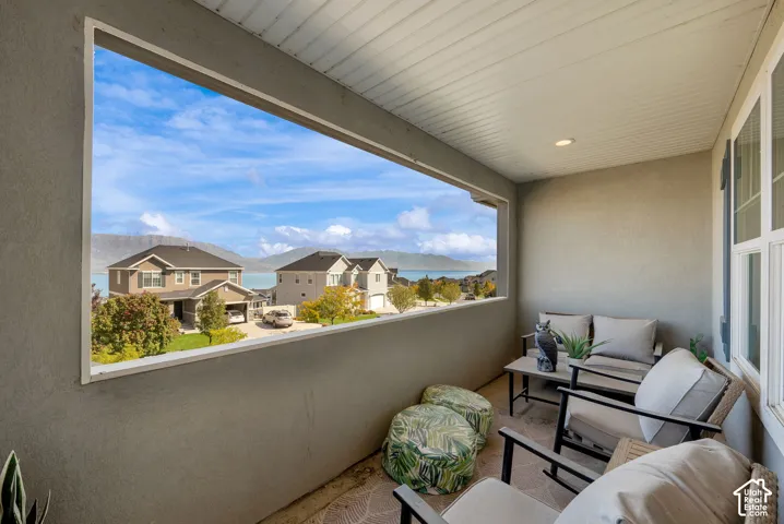 Covered balcony featuring recessed lighting, a solid half-wall enclosure, and expansive scenery of mountains and water