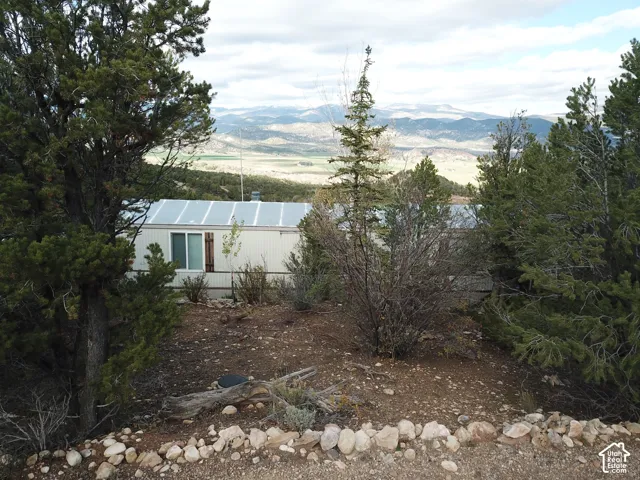 Single-story exterior with metal siding, dual-pane sliding windows, and mountain backdrop