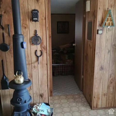 Cast iron stove with integrated chimney pipe and wood-panelled wall finishes