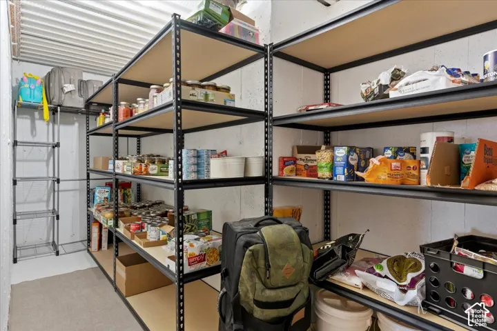 Storage area featuring industrial-style black metal shelving units and concrete wall construction