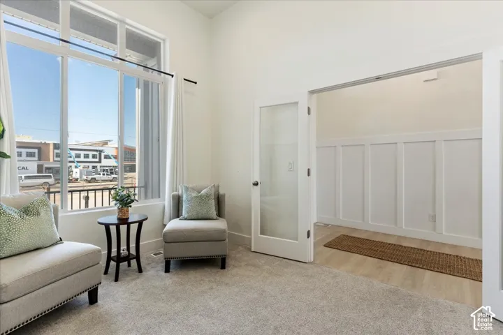 High ceilings with expansive multi-pane windows, glass-panel French doors, and decorative wall paneling