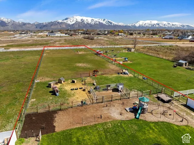 Expansive parcel featuring a fenced perimeter, open pasture, and mountain backdrop