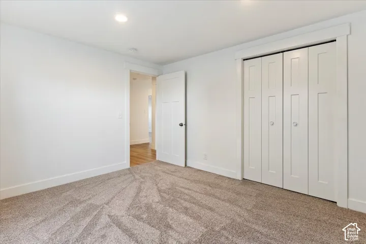 Room featuring neutral wall-to-wall carpeting, recessed ceiling lighting, and a white interior door