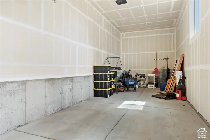 Finished garage space featuring concrete flooring, painted drywall, and high ceilings