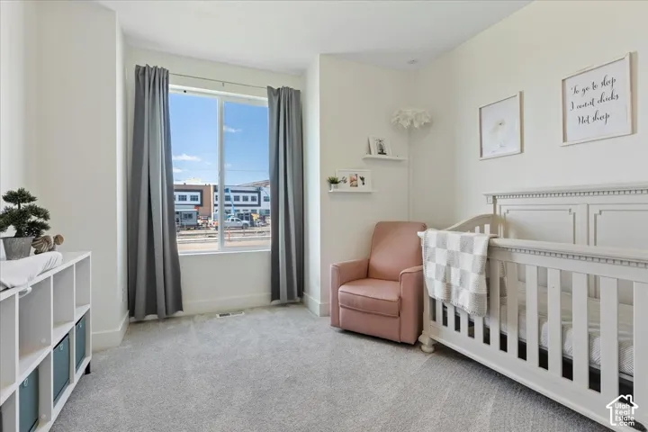 Neutral-toned wall-to-wall carpeting, large window, and minimalist floating wall shelves