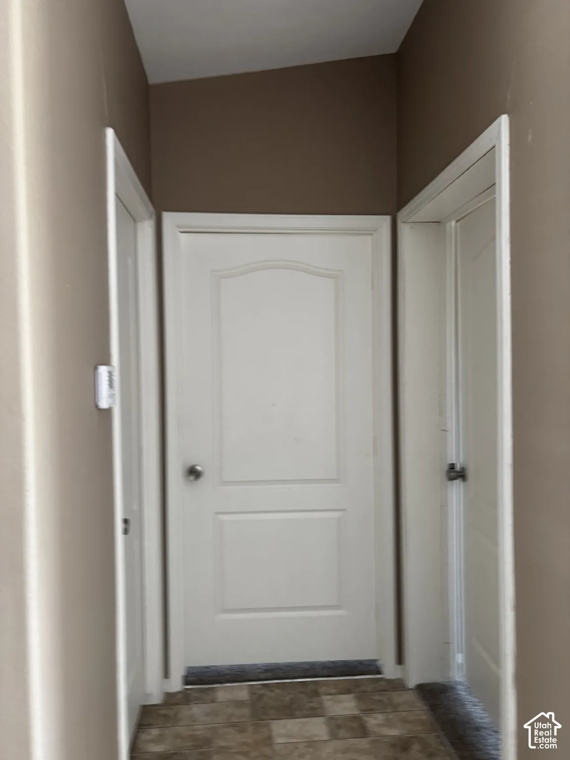 Three white interior doors with arched-top panels and brushed nickel hardware, complemented by tiled flooring