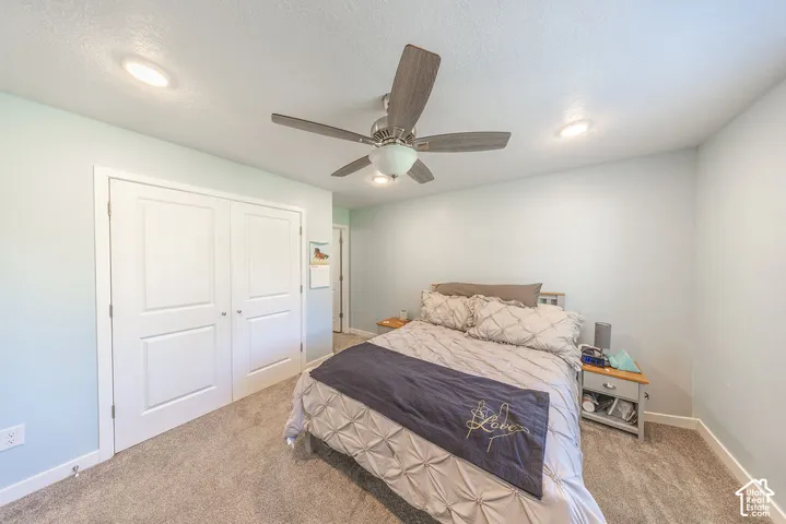 Room featuring neutral carpeting, recessed lighting, double-panel closet doors, and a ceiling fan with integrated lighting