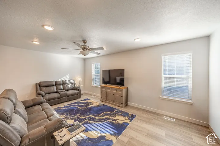 Neutral-toned interior featuring recessed lighting, a ceiling fan, wood-finish flooring, and windows with horizontal blinds