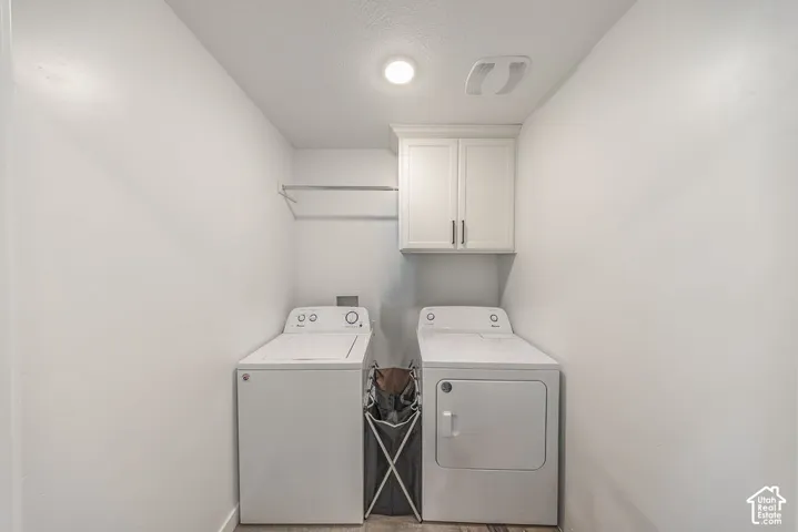 Laundry area featuring white shaker-style wall cabinetry and a mounted hanging rod