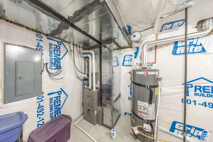 Mechanical room featuring a gas-fired furnace, water heater, electrical panel, and metal ductwork