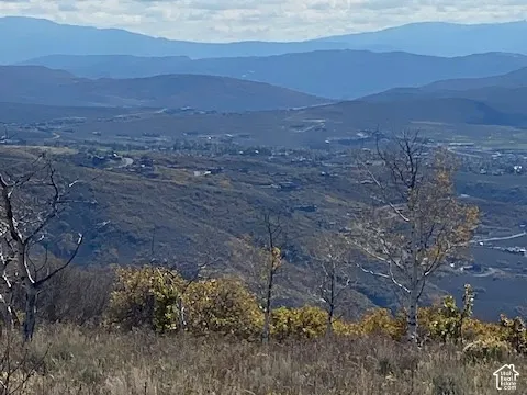 Expansive landscape featuring rolling mountain ranges and varied terrain