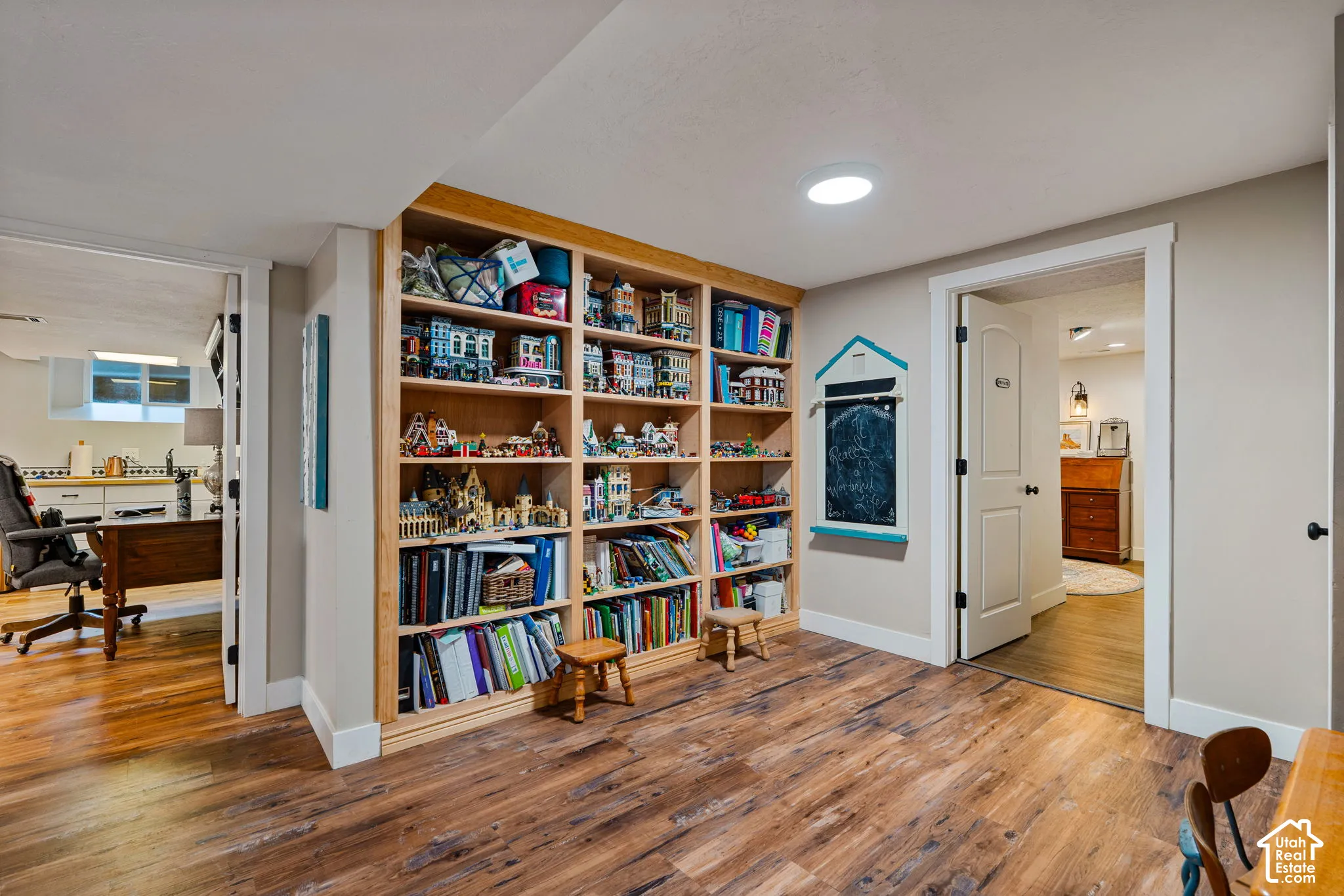 Built-in floor-to-ceiling wood shelving, wood-finish flooring, and solid-core interior doors