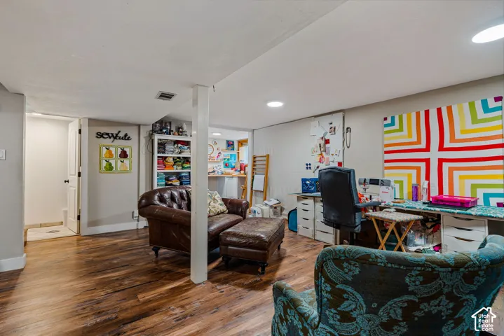 Finished lower-level space featuring wood-finish flooring and recessed lighting