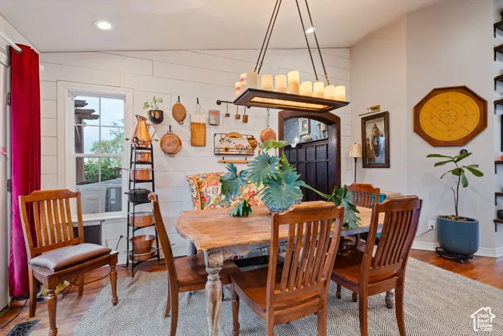 Shiplap wall paneling, custom rectangular chandelier with faux-candle lighting, multi-pane window, and arched entry with wood detailing