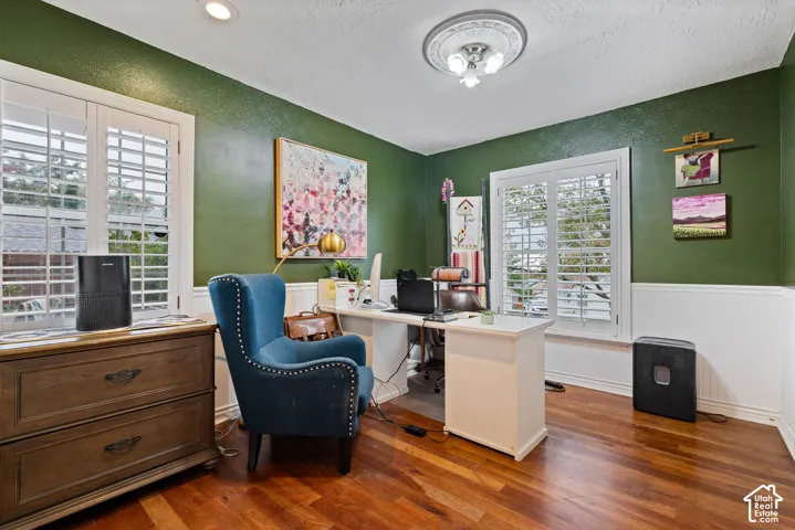 Room featuring wood-finish flooring, white wainscoting, plantation shutters, recessed lighting, and a central ceiling light with a decorative medallion