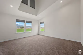 Vaulted ceilings, neutral wall tones in the primary bedroom