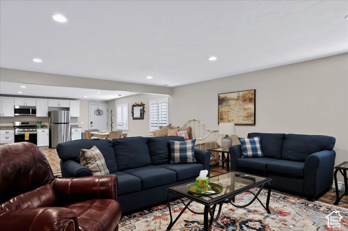 Open-concept interior featuring recessed lighting, plantation shutters, and wood-finish flooring