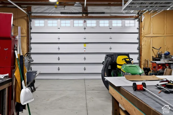 Multi-car garage featuring a sectional door with integrated windows, concrete flooring, and insulated wall paneling