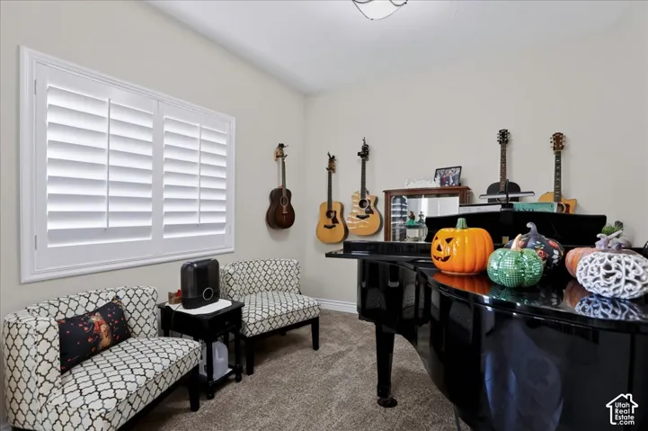 Neutral wall color, bright interior space with white plantation shutters, and ceiling-mounted lighting